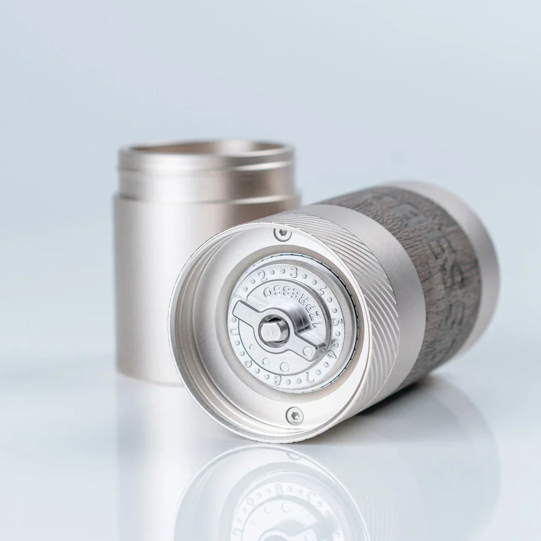 1Zpresso Q manual coffee grinder with foldable handle and dark wood knob.