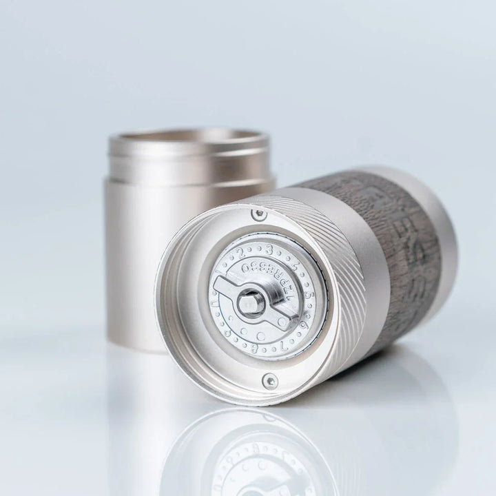 1Zpresso Q manual coffee grinder with foldable handle and dark wood knob.